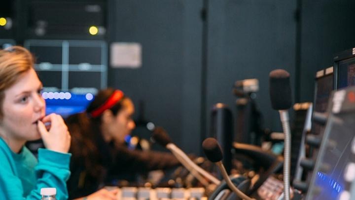 Three female students work the communications console at 澳门金沙线上赌博官网's newsroom, TigerTV