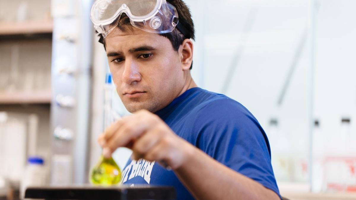 Student looking at yellow fluid in test tube