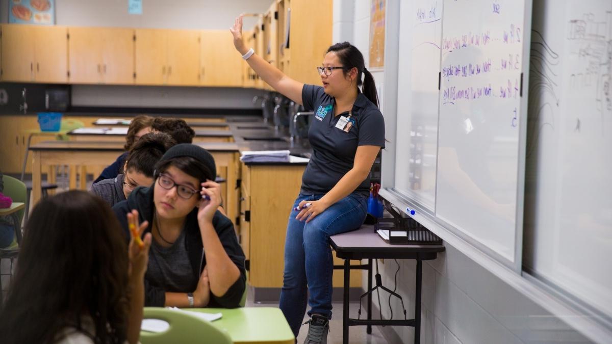 澳门金沙线上赌博官网 student teaching a high school classroom, while standing at whiteboard