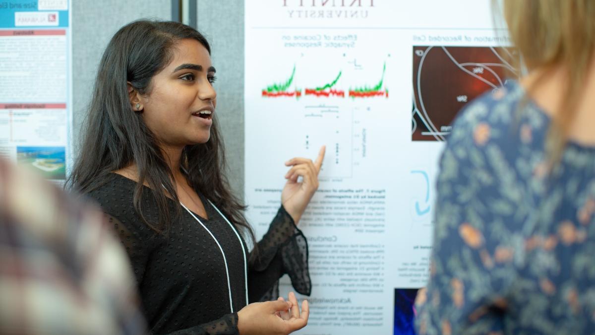 a student presents a poster at the summer undergraduate research symposium